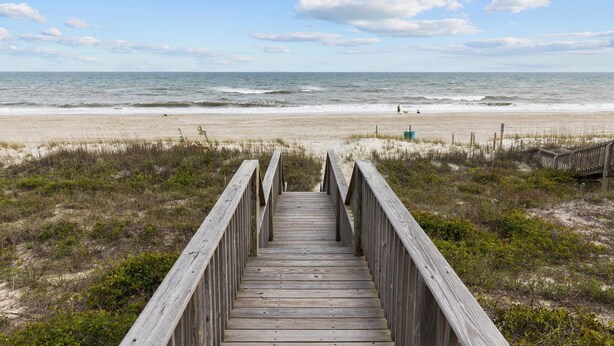 A wooden boardwalk leading to a beach with a clear view of the ocean and a sandy shore. - 4BR Ocean Front - King MBR with Views! (Emerald Isle)