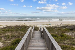 A wooden boardwalk leading to a beach with a clear view of the ocean and a sandy shore. - 4BR Ocean Front - King MBR with Views! (Emerald Isle)