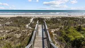 A wooden boardwalk leading to a beach with a clear sky and ocean view. - 4BR Ocean Front Dog Friendly Duplex - Rent both sides! (Emerald Isle)