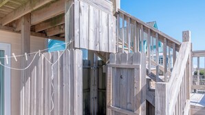 A wooden deck with a wooden staircase leading to a covered area. - 4BR Ocean Front - DOG OK - Close to town! (Emerald Isle)
