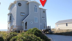 A two-story building with a balcony, a staircase, and a dock. - 3BR- Dogs OK- Ocean Front - Master Suite (Emerald Isle)