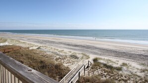 A beach with a wooden boardwalk leading to the shore. - 3BR- Dogs OK- Ocean Front - Master Suite (Emerald Isle)