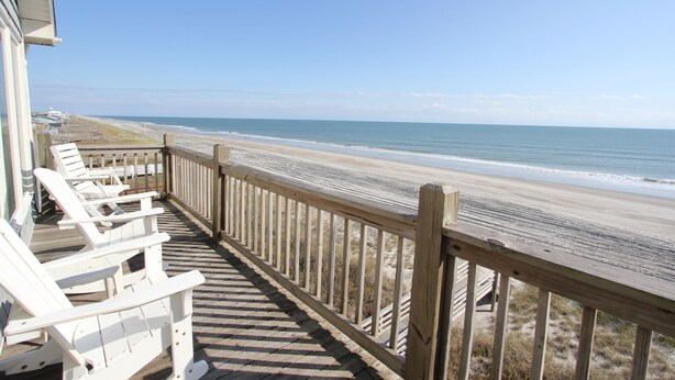 A wooden deck with white lounge chairs overlooking a beach. - 3BR- Dogs OK- Ocean Front - Master Suite (Emerald Isle)