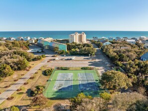 Enjoy a game of tennis surrounded by lush greenery and ocean views.