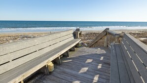 A wooden boardwalk leading to a beach with benches and a clear view of the ocean. - Sound of the Sea 203N - 2BR Condo w/ Pool! (Emerald Isle)