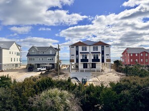 A beachfront property with multiple houses, a sandy beach, and a clear sky. - POOL & DOGS WELCOME! Easy Beach Access (Emerald Isle)