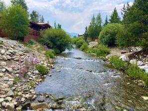 A river flowing through a forested area with wooden cabins. - Rock Crawlers Retreat romantic and warm 5 min to Breck on Shuttle route (Breckenridge)