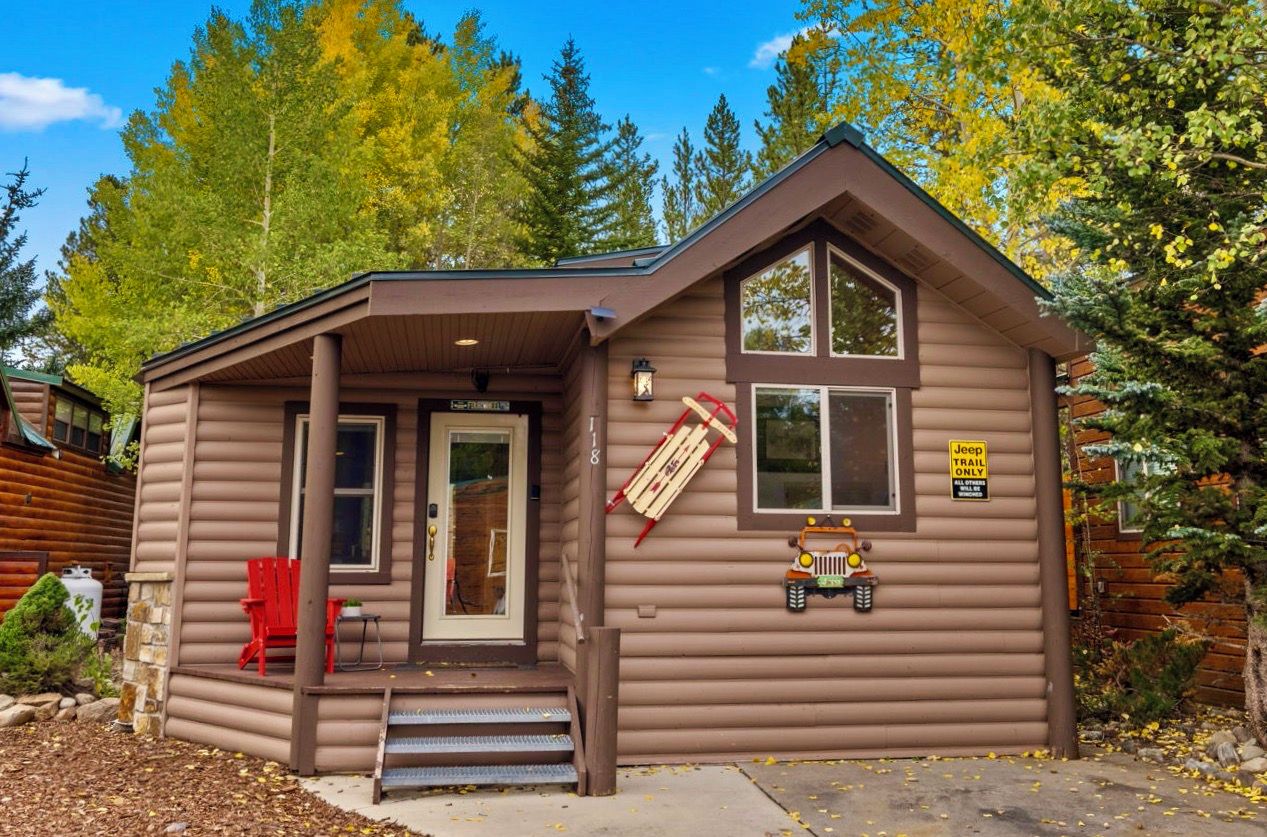 A cabin with a porch, a red chair, and a sign indicating it's a Jeep Trail Only area.