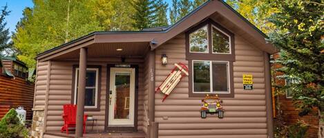A cabin with a porch, a red chair, and a sign indicating it's a Jeep Trail Only area.