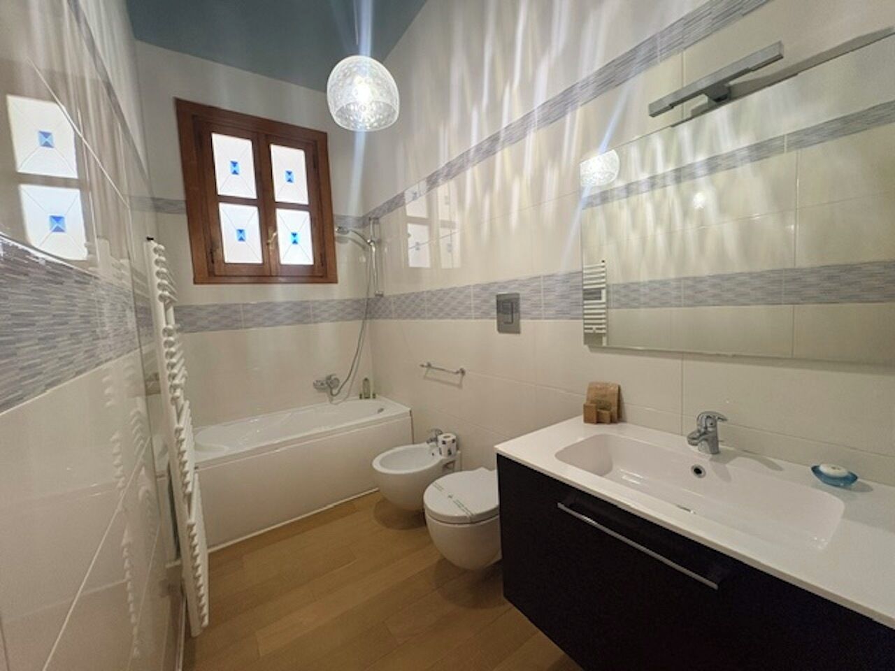 Un baño con bañera, lavamanos, inodoro y ducha.