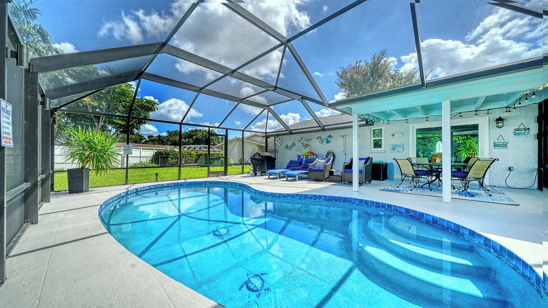 Une piscine extérieure couverte, dotée de chaises longues et d’un espace patio.