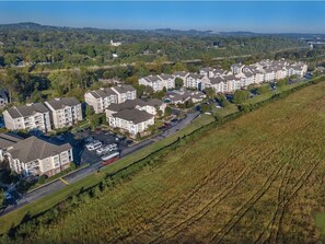 Residential area with modern apartment buildings set amidst green fields.
