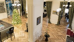 A spacious room with a wooden herringbone floor, a Christmas tree, and a dining area with a table and chairs. - Arté Boutique Hotel (Tirana)