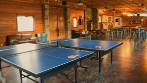 A room with ping pong tables, wooden walls, and ceiling fans. - # 7 Son’s Rio Cibolo Safari Cabin (Marion)
