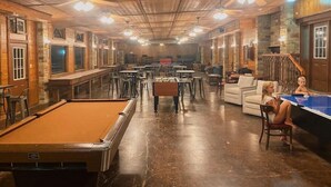 Ein geräumiger Aufenthaltsbereich mit Billardtisch, verschiedenen Sitzgelegenheiten und einer Bar.