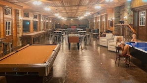 Ein geräumiger Aufenthaltsbereich mit Billardtisch, verschiedenen Sitzgelegenheiten und einer Bar.