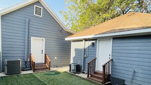 A residential property with a covered patio area, two doors, and a small outdoor seating arrangement. - Cute 2 bedroom in the heart of Houston  (Houston)
