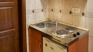Una cocina compacta con armarios de madera, un lavaplatos integrado y un lavavajillas.