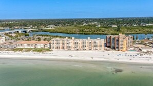 A coastal hotel with multiple buildings, a beach, and a river.