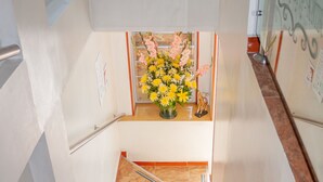 Een trap die leidt naar een kamer met een bloemstuk op een tafel.