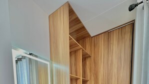 A modern bathroom with a wooden vanity, a mirror, and a shower area. - COMODO MONOAMBIENTE EN EQUIPETROL CON PISCINA EN CONDOMINIO! (Santa Cruz de la Sierra)