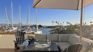 A deck with a table, chairs, and a glass-top coffee table. - Luxury waterfront! The Pagoda Beach House (Oxnard)