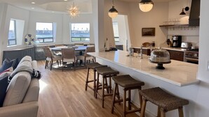 A spacious kitchen with a large island, bar stools, and a view of the city. - Luxury waterfront! The Pagoda Beach House (Oxnard)