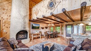 A rustic interior with a stone fireplace, wooden furniture, and a dining area. - Free Dollywood Tix/Views/Pool/Spacious/Arcade (Sevierville)