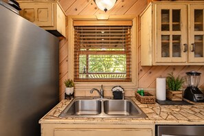 A kitchen with a stainless steel refrigerator, double sink, wooden cabinets, a window with blinds, and a blender on the counter. - Free Dollywood Tix/Views/Pool/Spacious/Arcade (Sevierville)