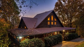 A wooden cabin with a steeply pitched roof, large windows, and a porch area. - Free Dollywood Tix/Views/Pool/Spacious/Arcade (Sevierville)