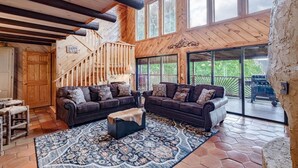 A spacious living area with a large wooden staircase, a dark brown leather sofa set, and a patterned rug. - Free Dollywood Tix/Views/Pool/Spacious/Arcade (Sevierville)
