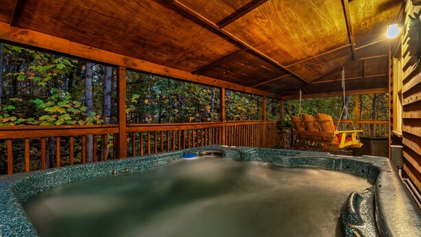 A hot tub area with a wooden deck, surrounded by trees. - Free Dollywood Tix/Views/Pool/Spacious/Arcade (Sevierville)