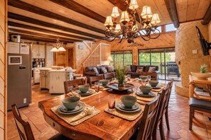 A spacious dining area with a long wooden table set for a meal, surrounded by chairs. - Free Dollywood Tix/Views/Pool/Spacious/Arcade (Sevierville)