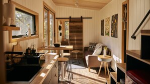 Ein gemütliches Blockhaus-Interieur mit Küchenzeile, Essbereich und Sitzgelegenheit.