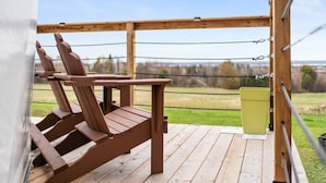 A wooden deck with two Adirondack chairs and a green trash bin. - Skye's Dome - A relaxing getaway (Debert)