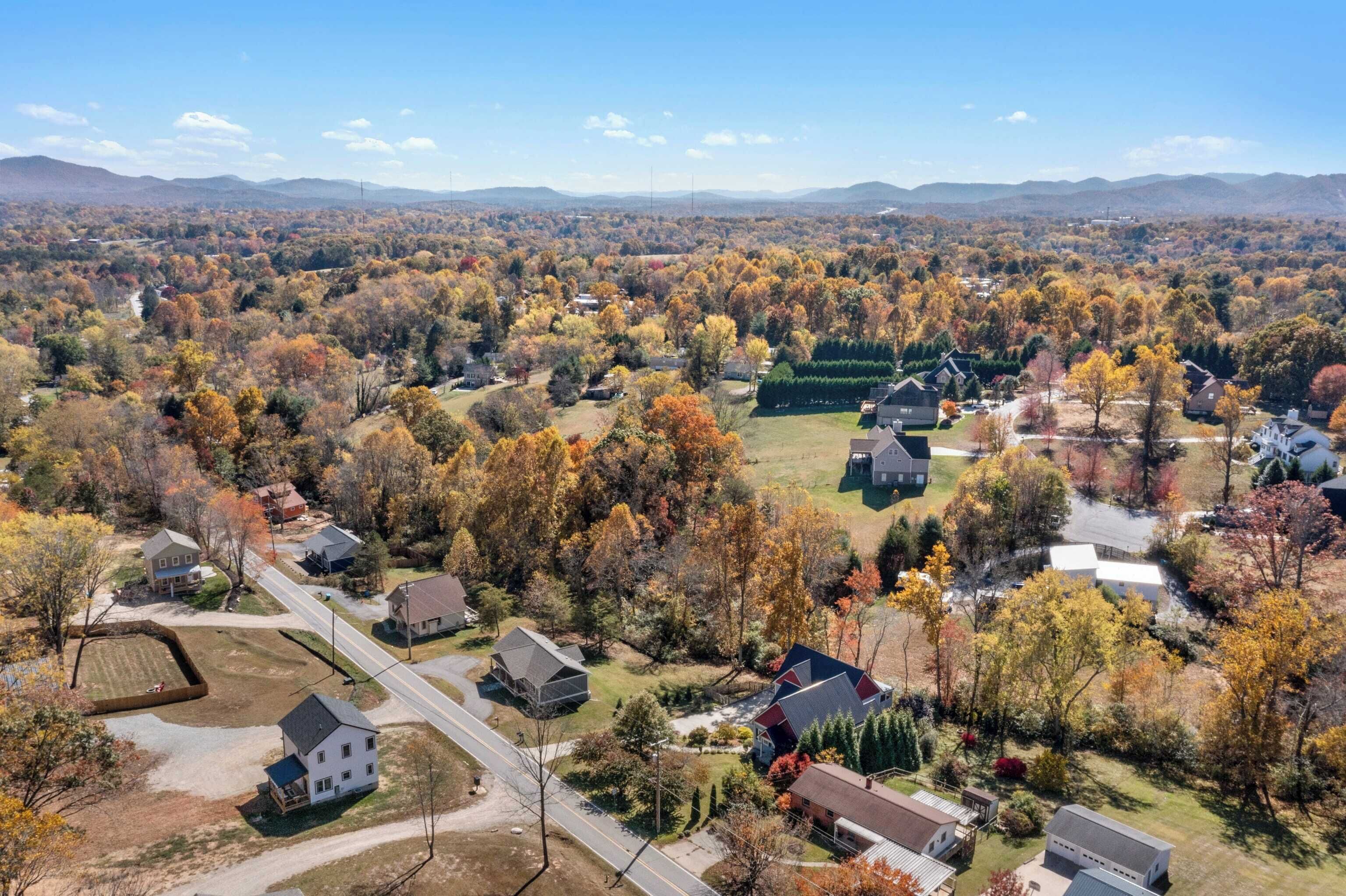 A residential area with houses, roads, and autumn foliage.