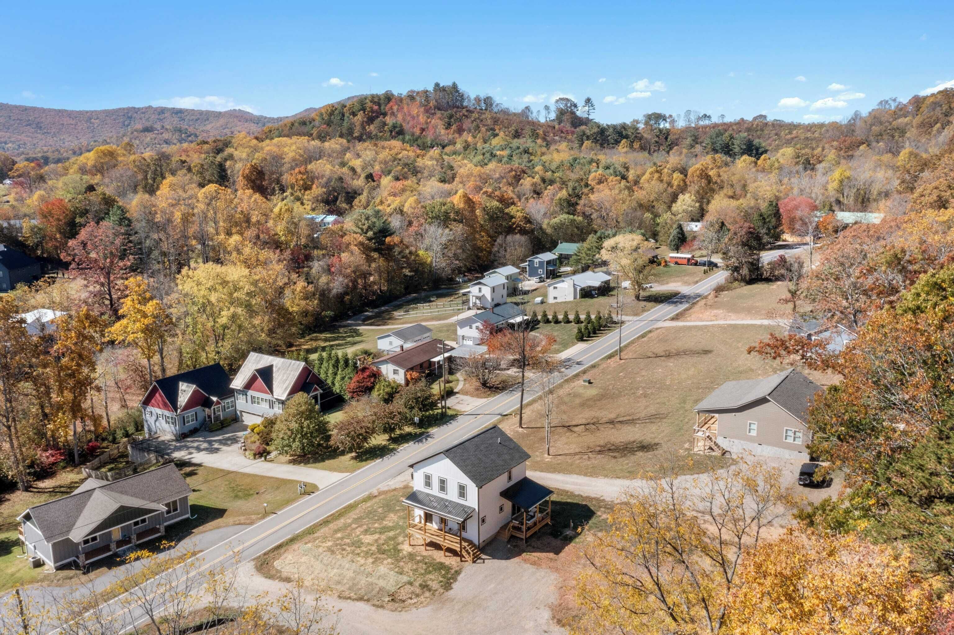 Ein Wohngebiet mit Häusern, einer Straße und Herbstlaub.