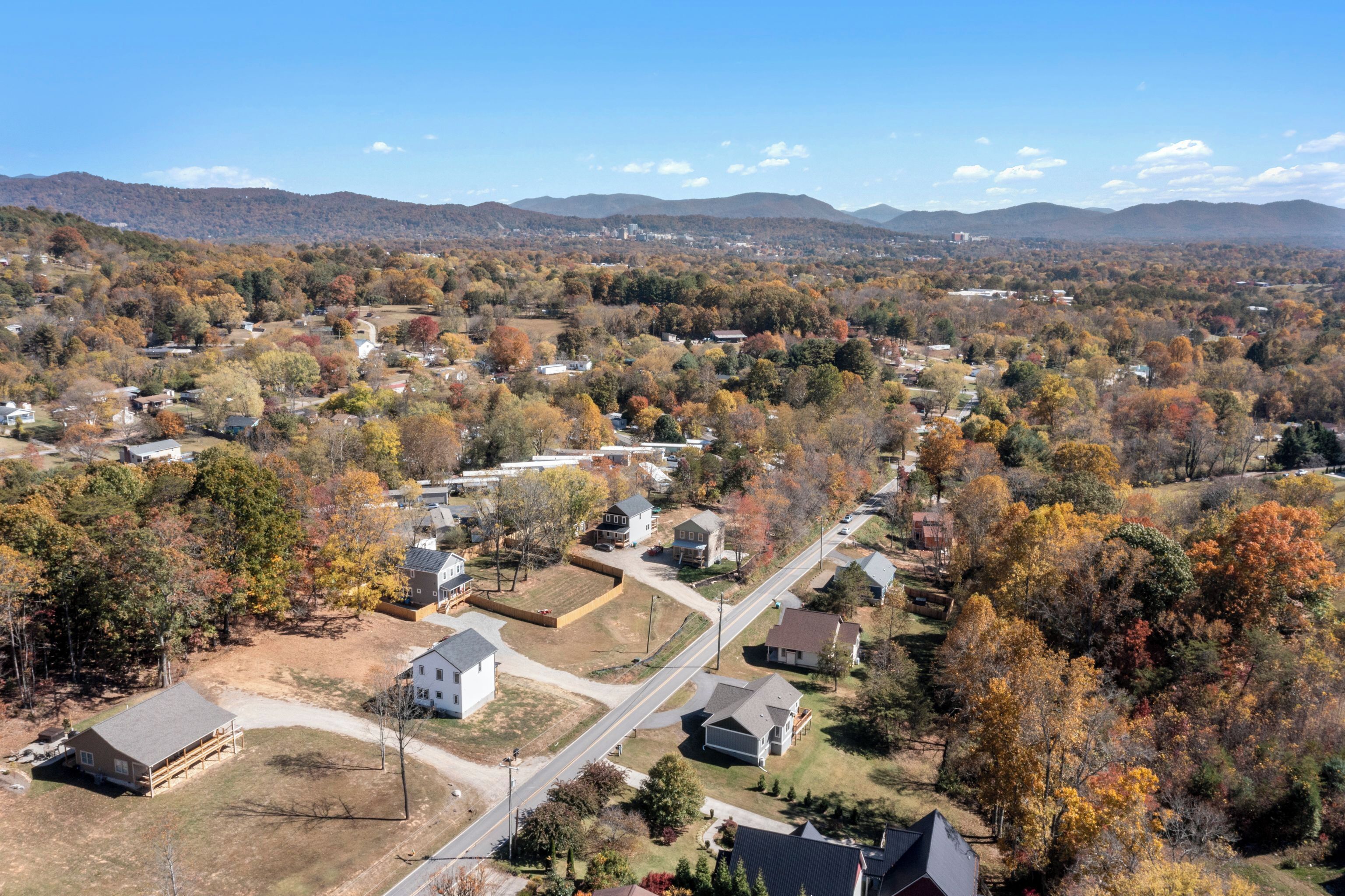 A residential area with houses, roads, and a hilly backdrop.