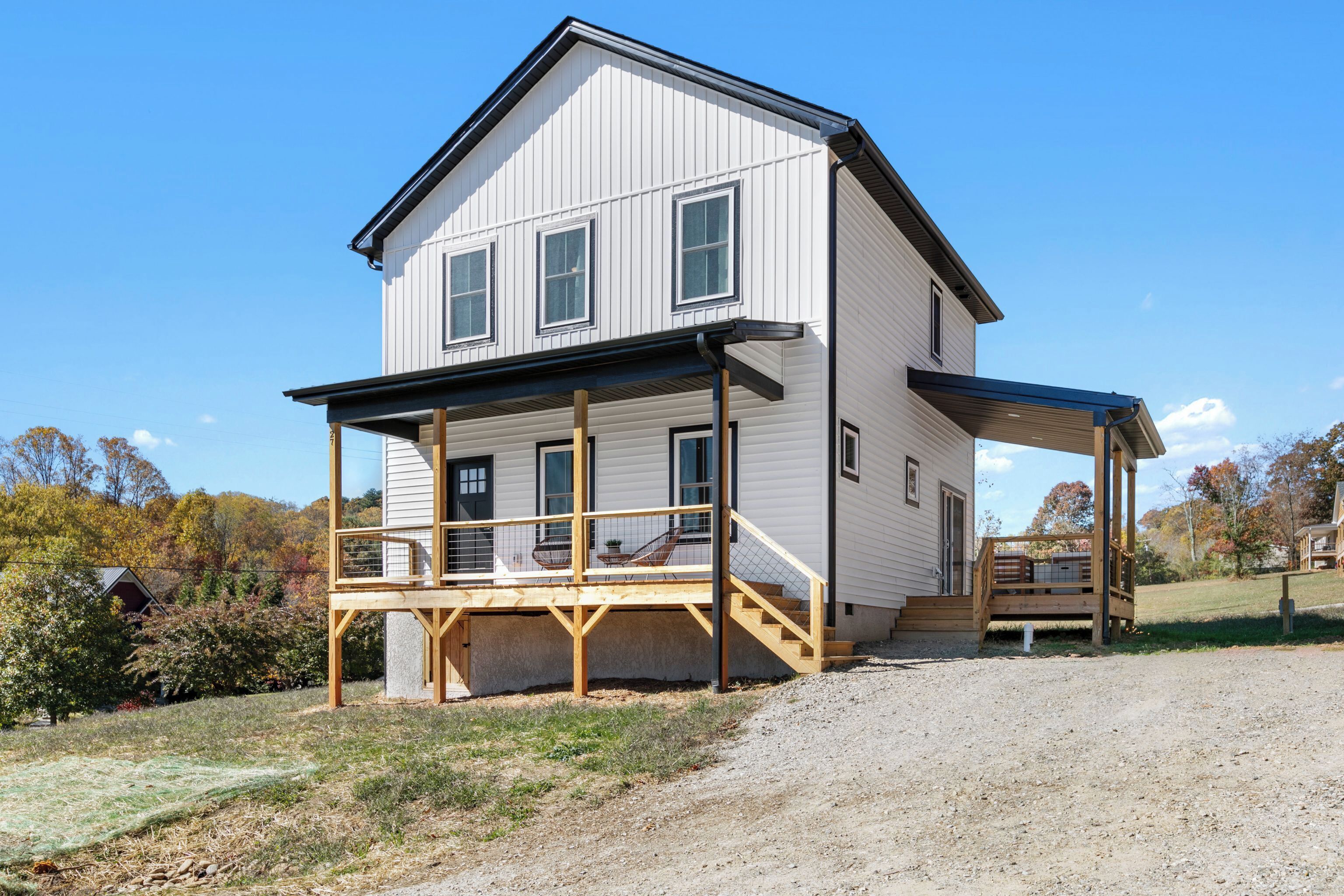 A two-story house with a covered porch and a front entrance.