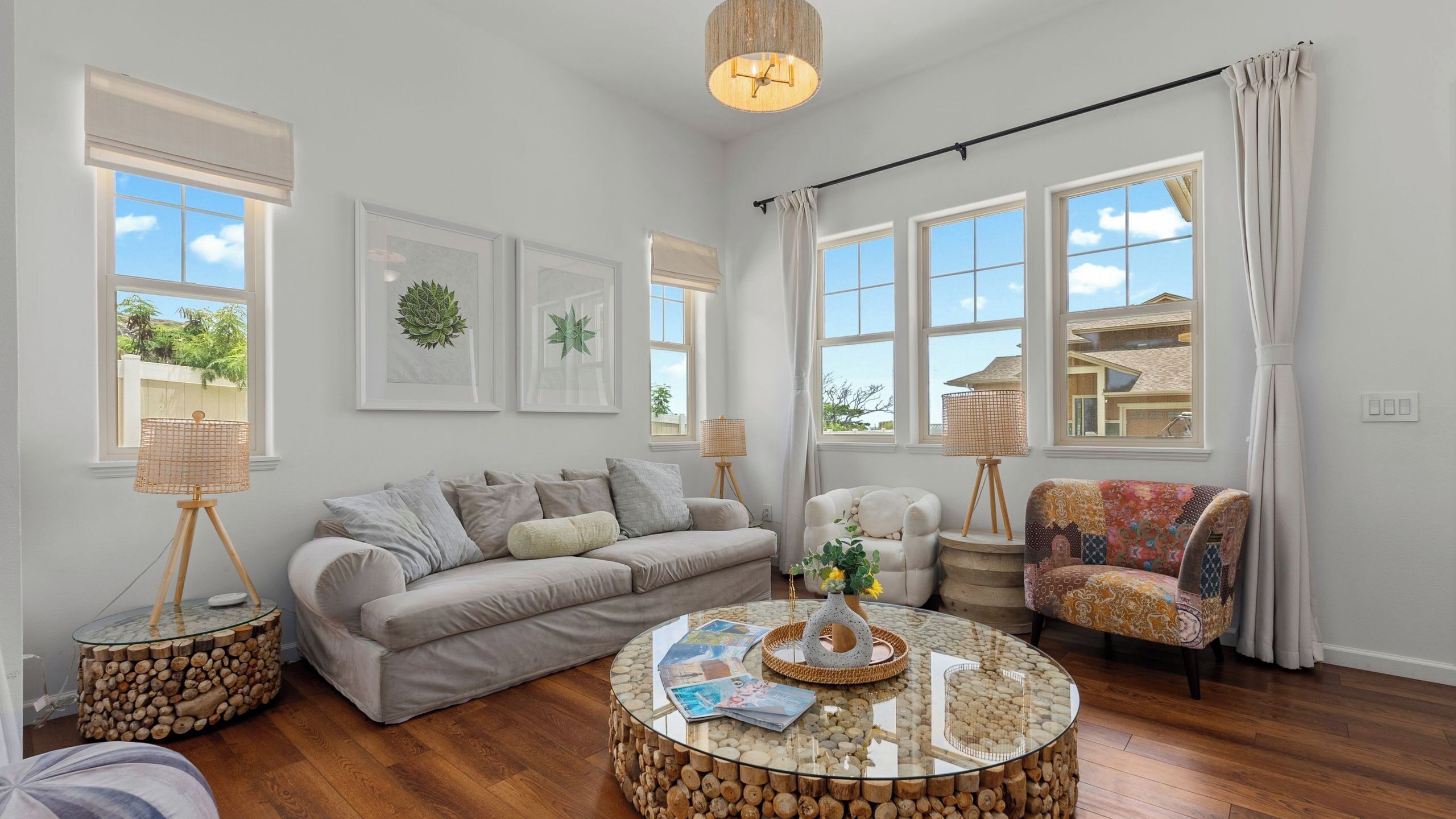 A living room with a sofa, a round coffee table, and a patterned armchair.