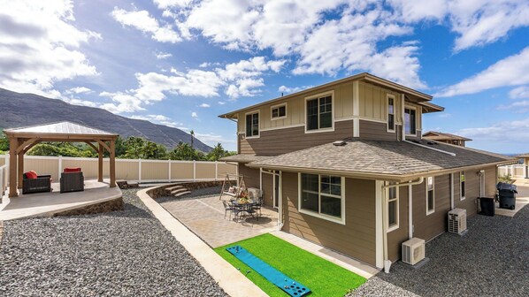 A two-story house with a patio, a swing set, and a small pool. - Makaha Villa by Avantstay Mountain + Ocean Views (Waianae)
