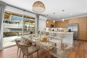 Una cocina moderna con una isla central, armarios de madera y electrodomésticos de acero inoxidable.