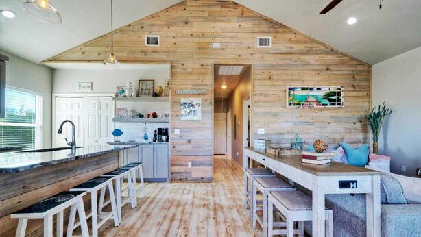 A spacious kitchen with a wooden ceiling, a central island, and a dining area with a bench. - Priv Pool, Walk to Marina + Eateries, 3 Mins to Beach Marlin Azul by Avantstay (Port Aransas)