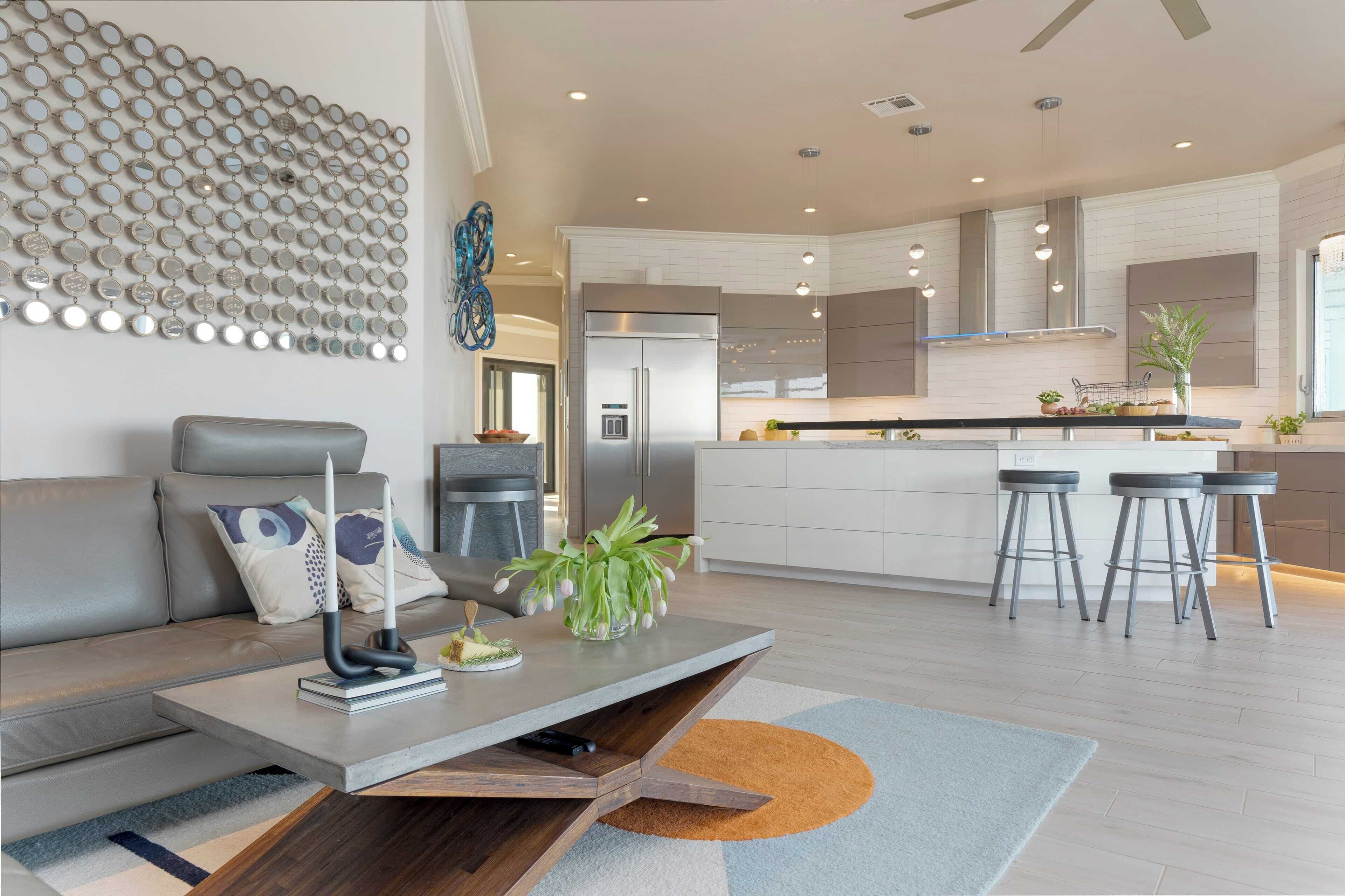 A modern kitchen with a central island, stainless steel appliances, and bar stools.