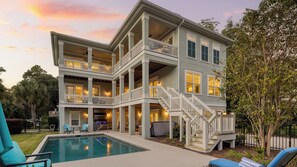 A multi-story building with a pool, outdoor seating, and a staircase leading to the upper levels. - Sweetbay by Avantstay 1 Min Walk to Beach + Pool (Hilton Head Island)