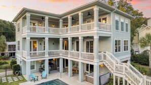 Une maison à plusieurs étages dotée de balcons, d’une piscine et d’un espace salon extérieur.