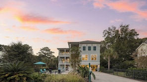 A two-story building with a balcony and a covered outdoor seating area. - Sweetbay by Avantstay 1 Min Walk to Beach + Pool (Hilton Head Island)