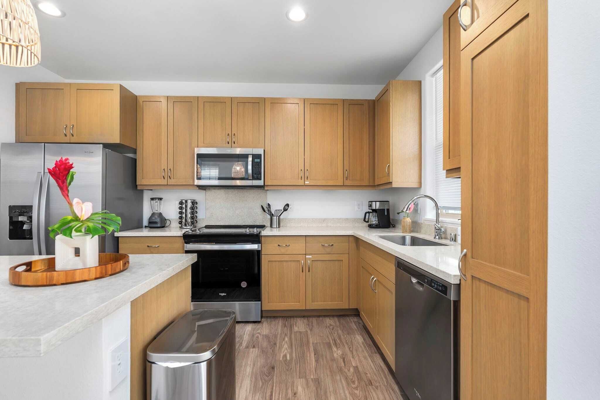 A modern kitchen with wooden cabinets, stainless steel appliances, and a granite countertop.
