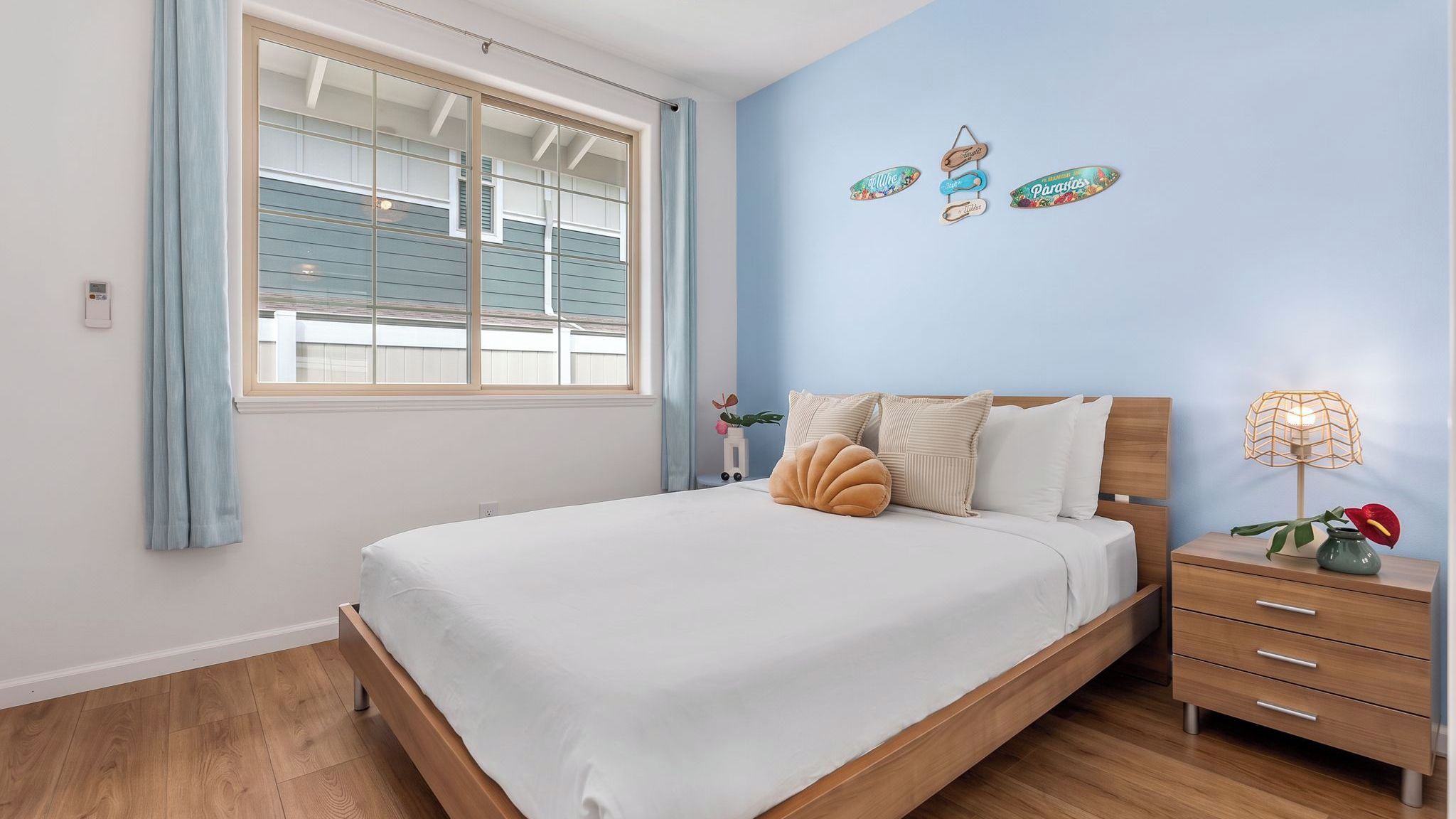 Quarto com cama, mesas de cabeceira, abajur e janela com persianas.