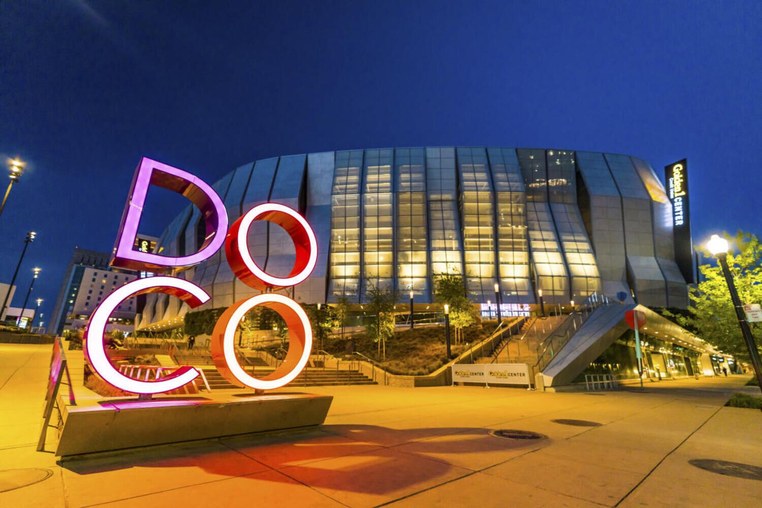A modern building with a glass facade and a prominent 'Doco' sign in the foreground.